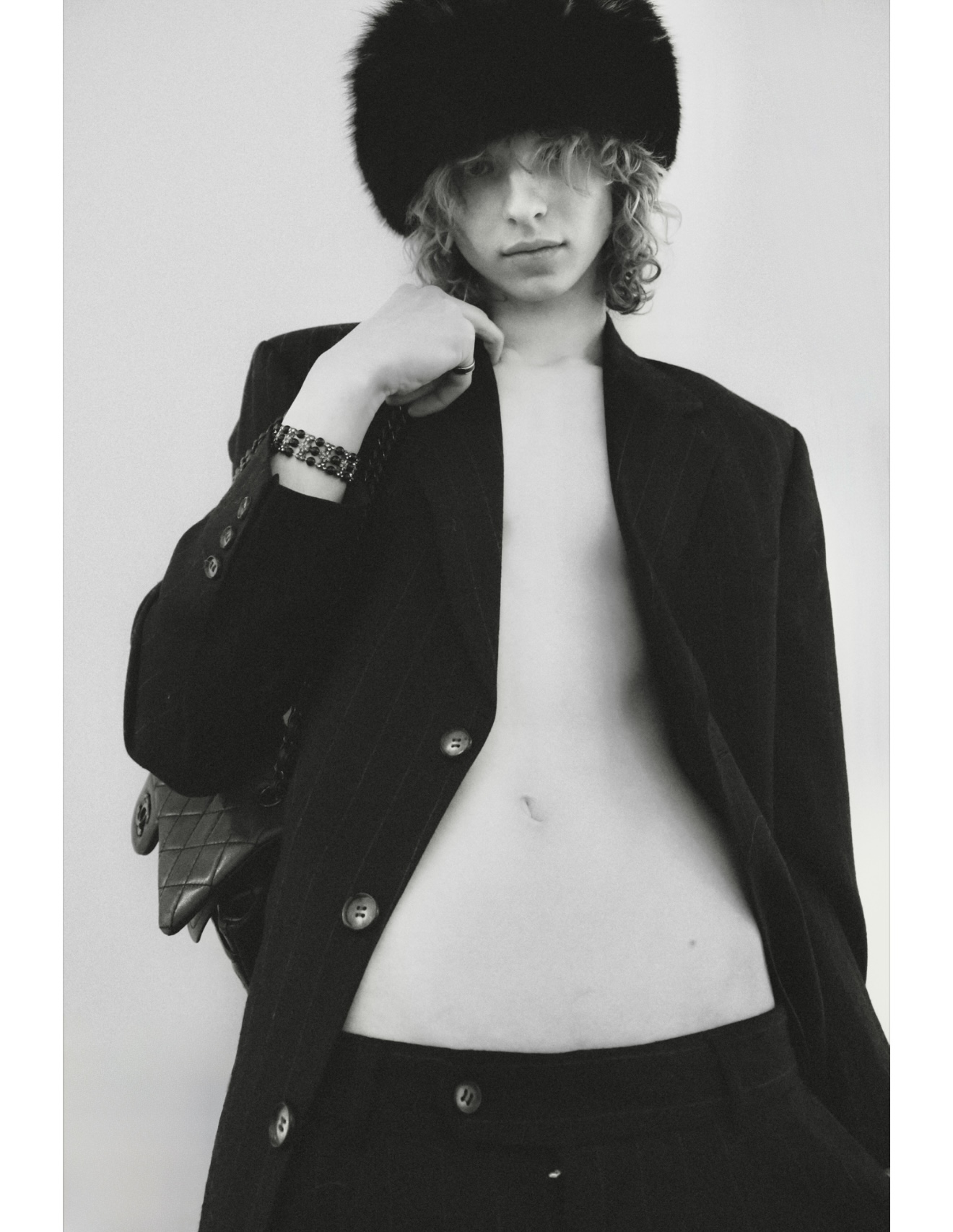 Monochrome studio editorial — model in a fur hat and pinstripe coat, editorial fashion photography directed and styled by Lauren
