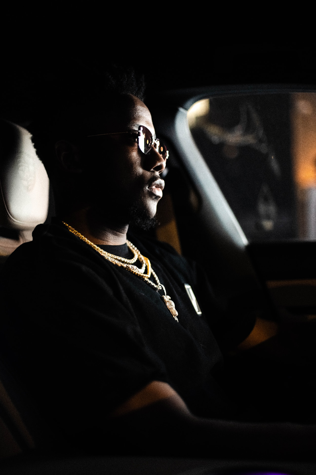 Editorial night shoot brand film for Ice Cartel — artist in sunglasses and gold chains lit inside a car, jewellery campaign photography by Maison Division